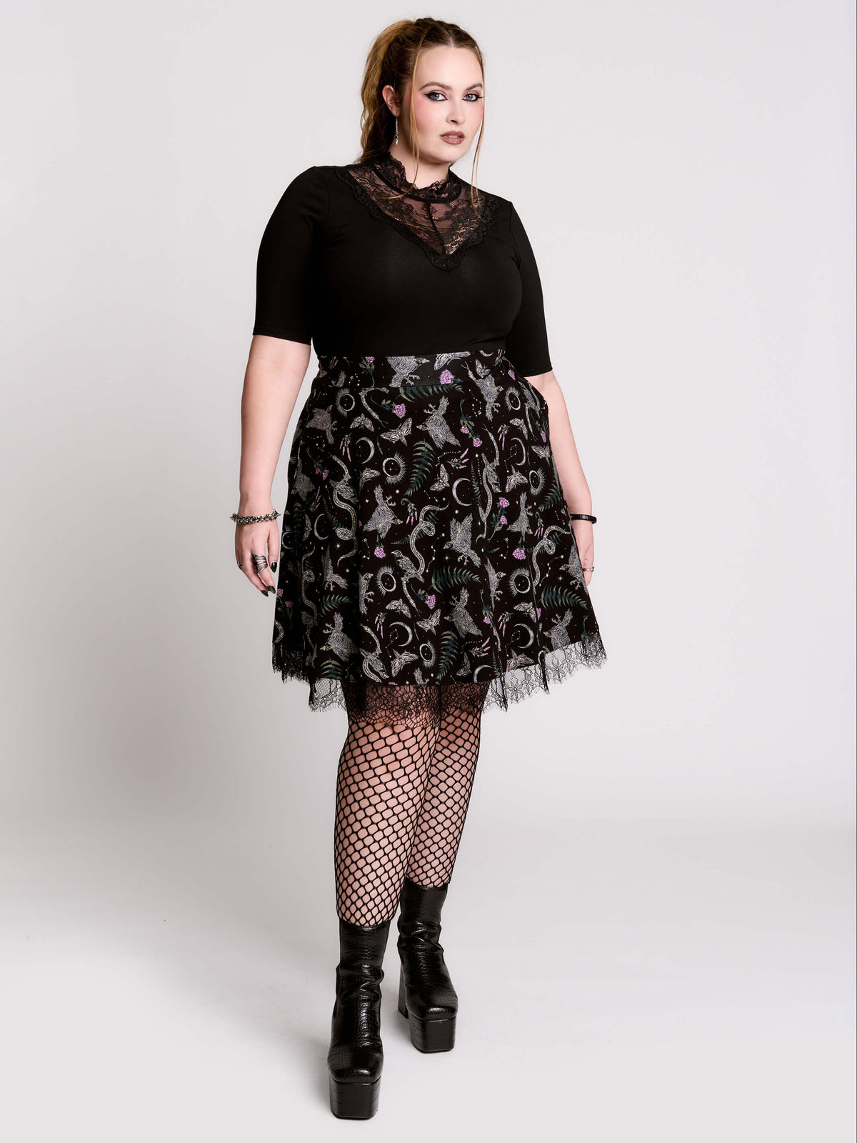 A black flared skirt featuring a gray and purple gothic print with lace hem.