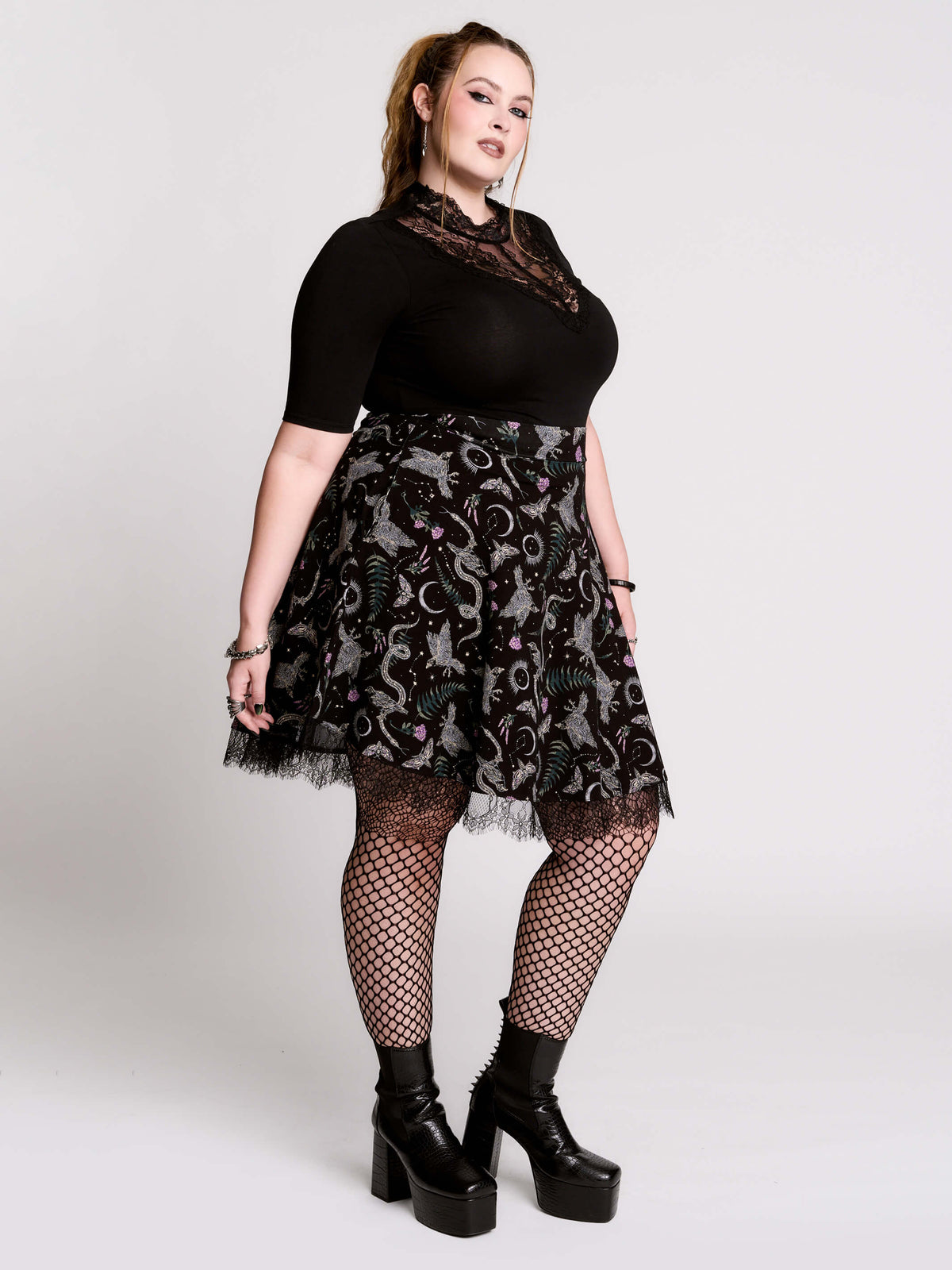 A black flared skirt featuring a gray and purple gothic print with lace hem.