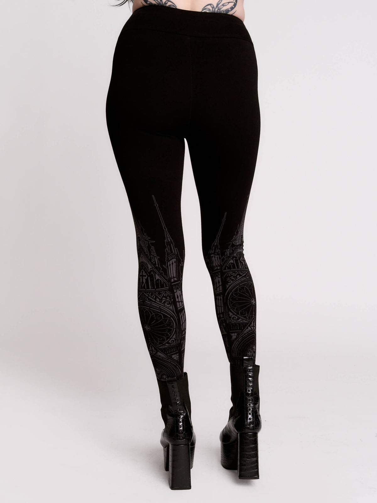 Black leggings with a dark gray gothic cathedral line-art print down the legs.