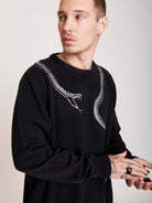 sweater with skeleton snake detail around neck.