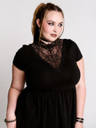 A black short-sleeve dress with a lace V-neckline.