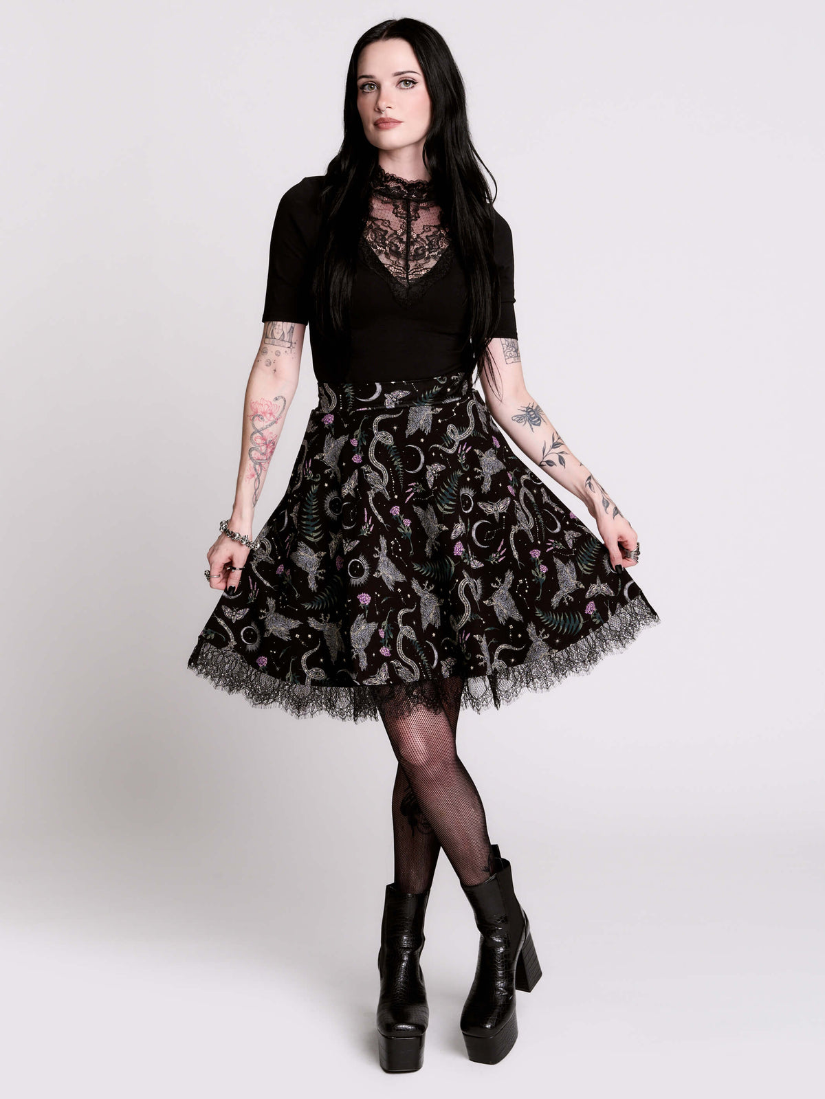 A  black flared skirt featuring a gray and purple gothic print with lace hem.