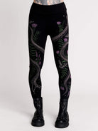 Black leggings with a detailed graphic print of a green fern, a purple flower, and a silver snake