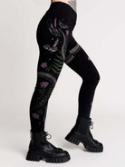 Black leggings with a detailed graphic print of a green fern, a purple flower, and a silver snake