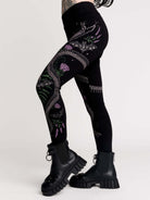 Black leggings with a detailed graphic print of a green fern, a purple flower, and a silver snake