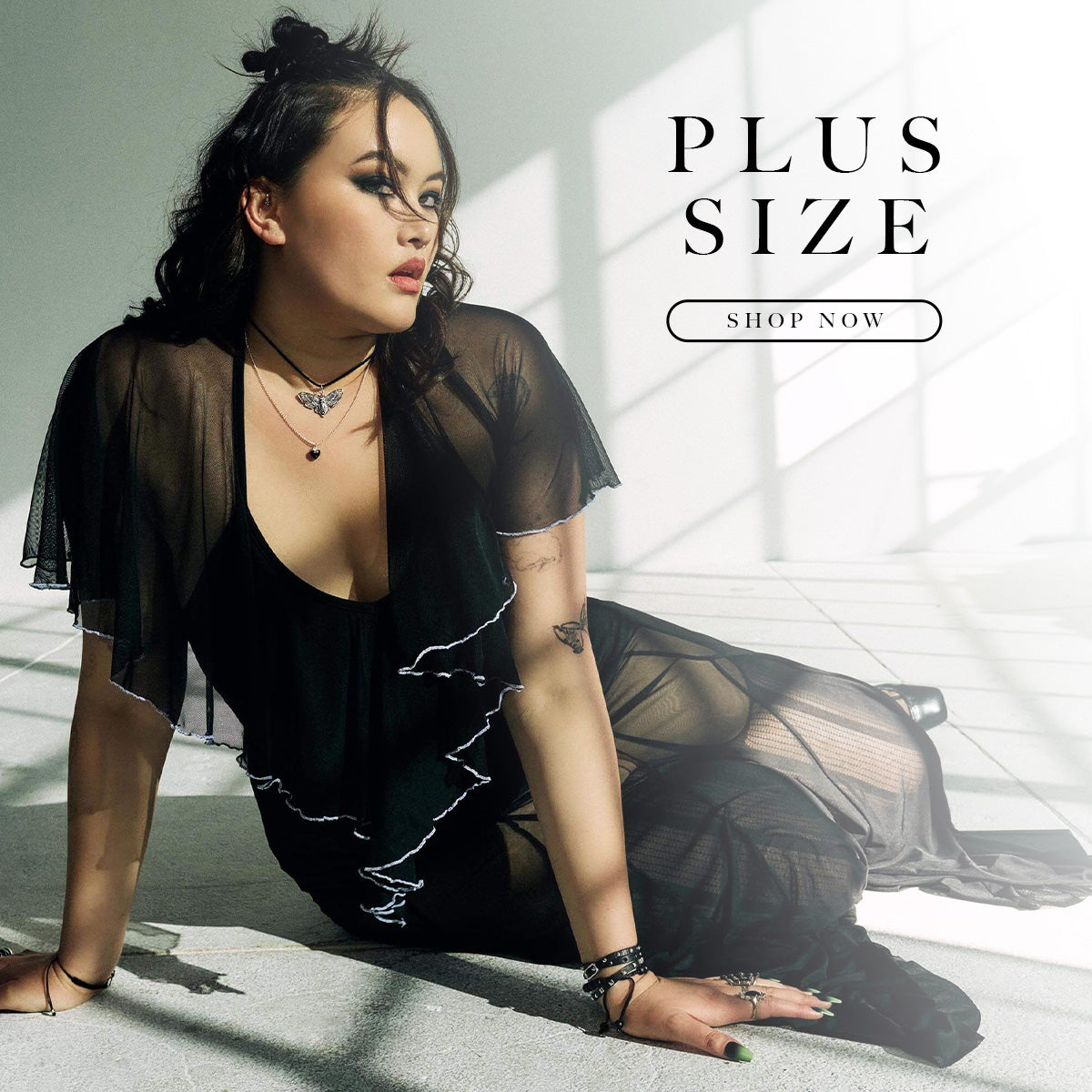 Woman wearing a black outfit with sheer elements, sitting on the floor with 'Plus Size' text overlay.