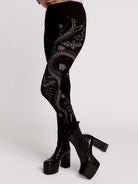 Black leggings with a detailed graphic print of a green fern, a purple flower, and a silver snake