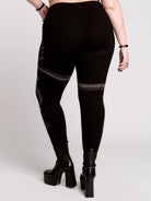 Black leggings with a detailed graphic print of a green fern, a purple flower, and a silver snake