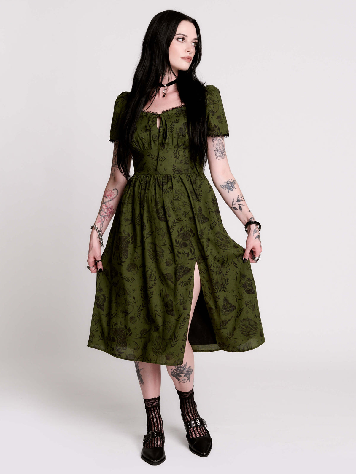 a short-sleeved olive green midi dress with a gothic pattern